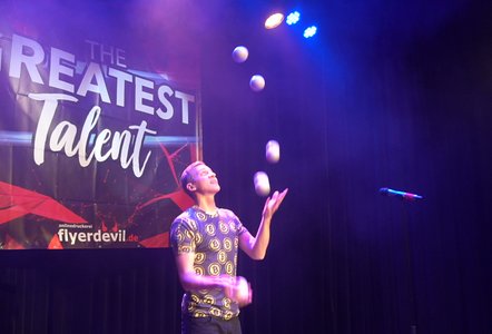 Jan Daumin jongliert mit vielen Bällen gleichzeitig, während er das Publikum in kurzweilige Geschichten einbindet. Weltklasse.